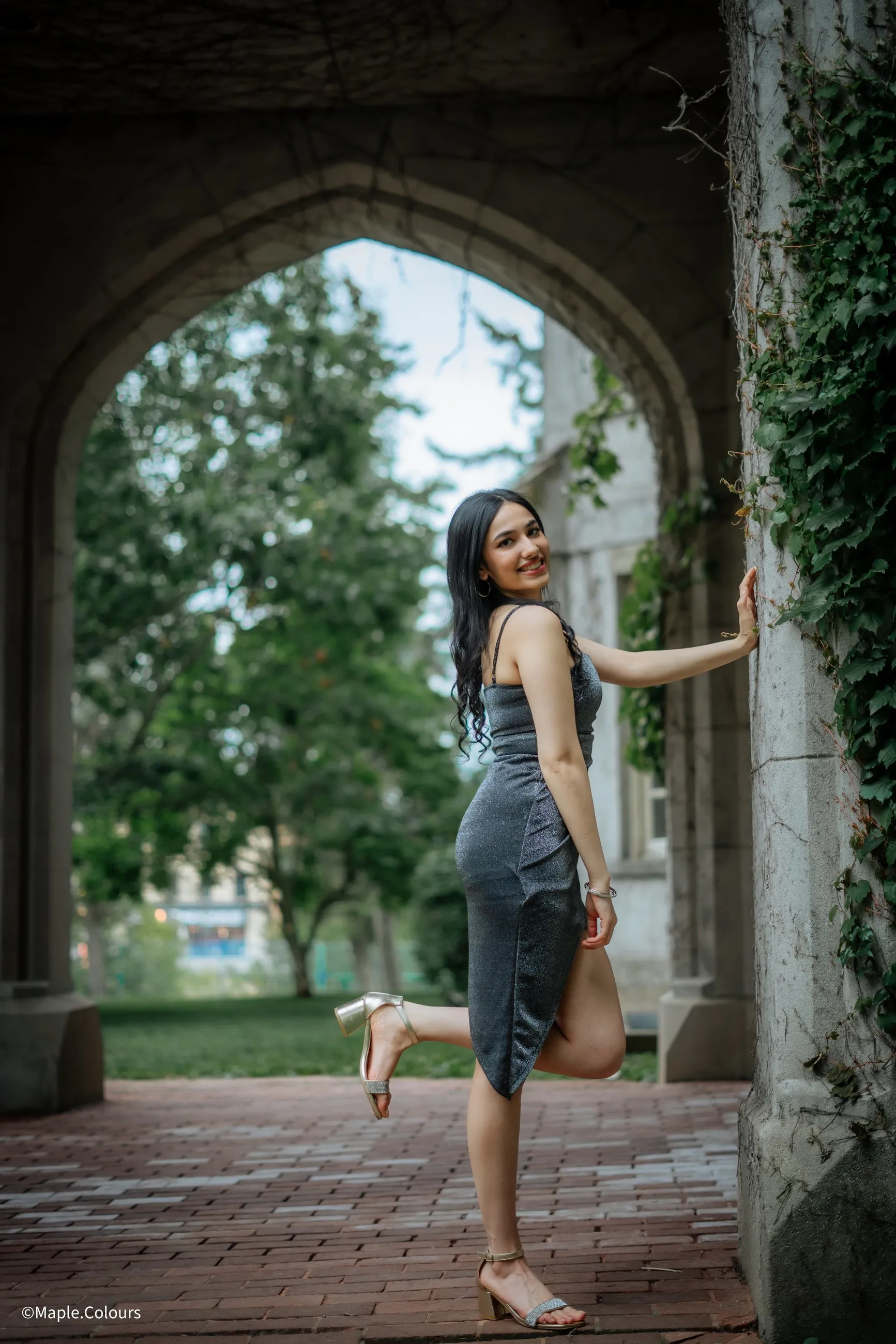 Portrait session beneath a stone archway framed with ivy